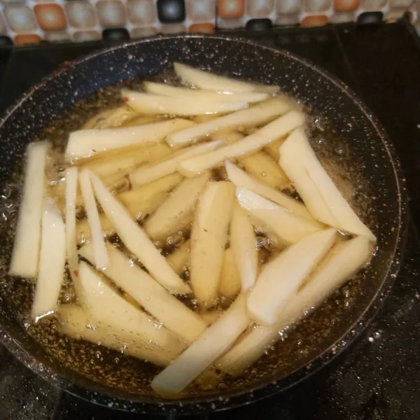 Goreng kentang dalam minyak panas hingga empuk.