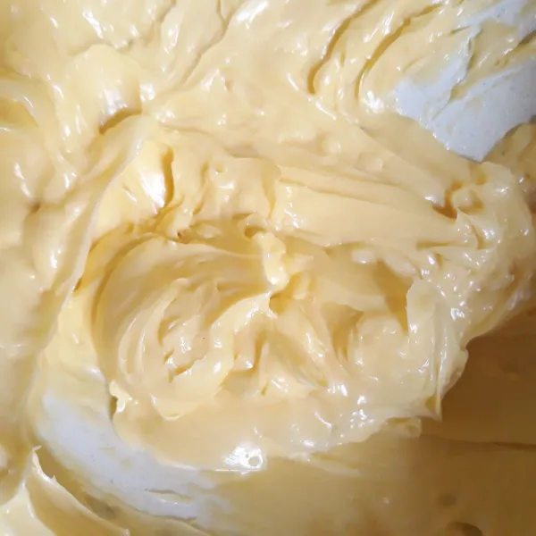 Campurkan butter dan gula pasir. Aduk hingga gula pasir cair. Tambahkan mentega. Aduk. Masukkan kuning telur. Aduk kembali hingga tercampur rata.