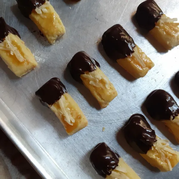 Lelehkan DCC dengan cara di tim. Celupkan kue yang telah matang ke dalam coklat leleh. Letakkan diatas loyang, biarkan dingin. Sajikan.