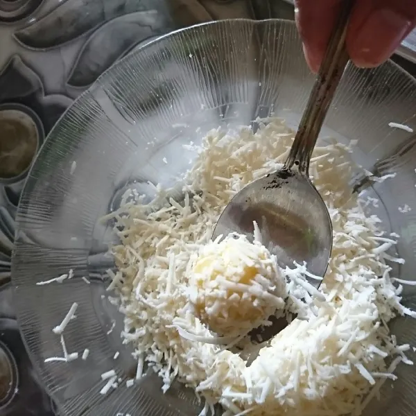 Ambil satu sendok teh adonan, bulatkan, masukkan ke putih telur lalu gulingkan le keju parut.