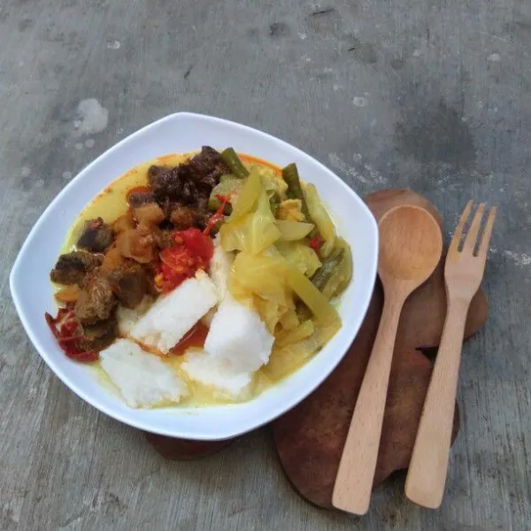 Siapkan piring saji, tata lontong di piring, tambahkan dengan rendang, sambal goreng hati sap, sambal lado merah dan siram dengan sayur.