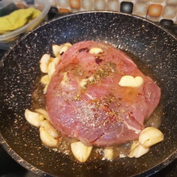 Letakkan daging, masak sebentar lalu tambahkan potongan bawang putih, bawang bombay dan baluri dengan salted butter di atas daging. Seasoning lagi sesuai step 1.