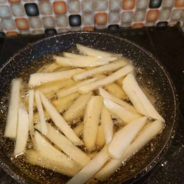 Goreng kentang dalam minyak panas hingga empuk