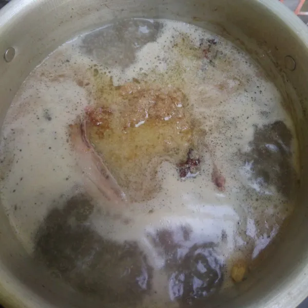 Masukkan tumisan bumbu dan beri bunga lawang, cengkeh, kapulaga hijau, rebus hingga ayam matang.