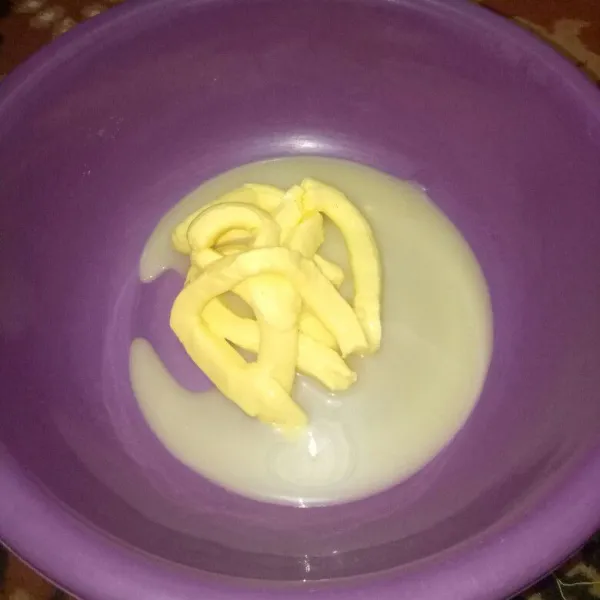 Siapkan wadah, aduk pakai spatula susu kental manis dan margarin sampai tercampur rata.