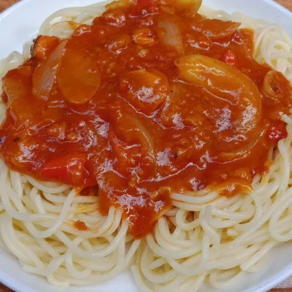 Tata spagetti di piring dan siram dengan saos lalu sajikan.