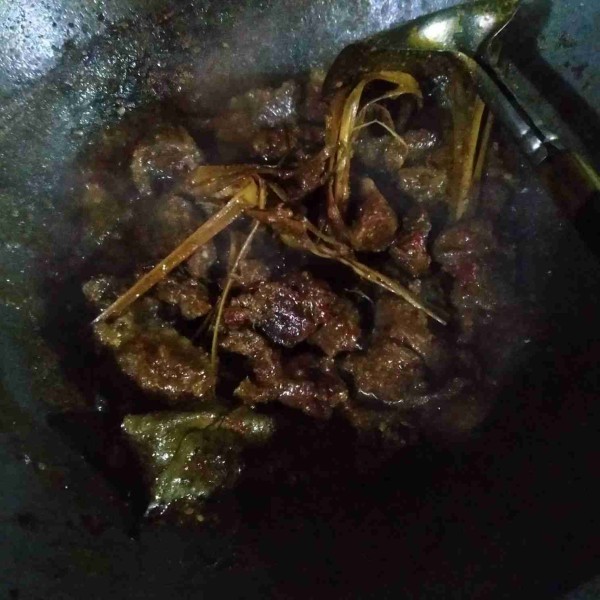 Pindah rendang ke wajan besar. Masak sampai empuk dan bumbu mengental dengan api cenderung kecil. Setelah matang, angkat.