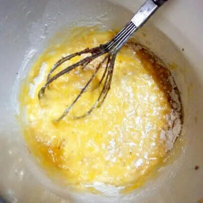 Masukkan terigu, telur, minyak goreng dan gula ke dalam wadah. Aduk rata dengan whisk dan spatula.