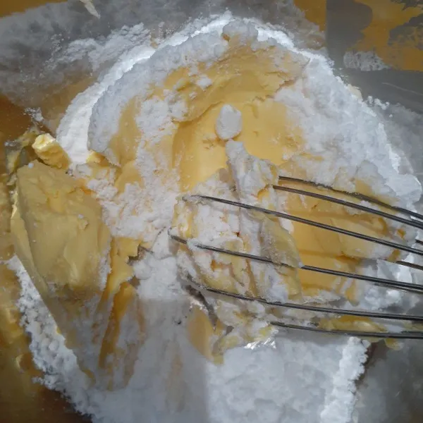 Kocok mentega dan gula halu menggunakan whiks, jangan terlalu lama mengocok, hingga gula dan mentega tercampur saja