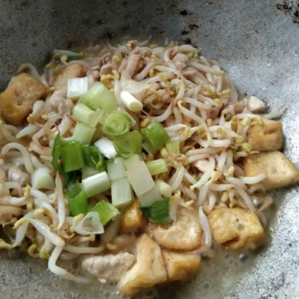Tambahkan irisan daun bawang, masak hingga daun bawang layu.