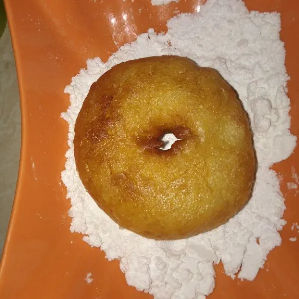 Setelah dingin, gulingkan donat ke dalam gula halus.