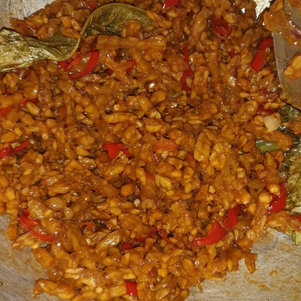 Masukkan tempe yang sudah digoreng tadi kemudian beri irisan bawang merah biarkan hingga santan meresap ke dalam tempe.