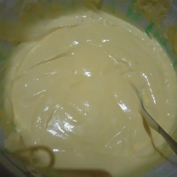 Tambahkan sedikit demi sedikit tepung, aduk hingga tercampur. Tambahkan pewarna kuning telur.