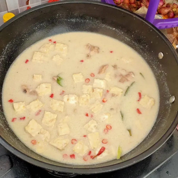 Masukkan pelengkap seperti tempe (bisa kentang) dan irisan cabe. Masak dengan api kecil sambil diaduk (agar santan tidak pecah) sampai ayam empuk. Angkat dan sajikan bersama ketupat.