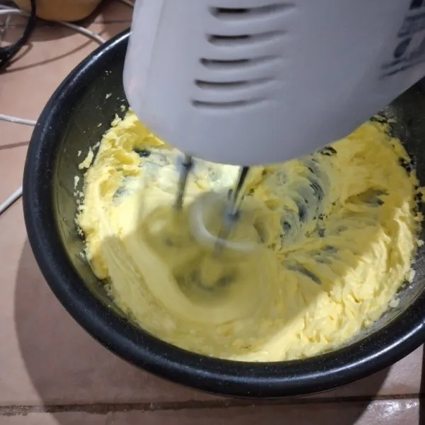 Dalam wadah lain kocok mentega dan gula halus hingga pucat mengembang, sisihkan.
