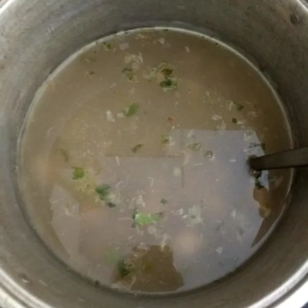 Selagi menunggu daging, masukkan bakso, cabai rawit hijau, garam, gula dan penyedap rasa di panci lain lalu rebus