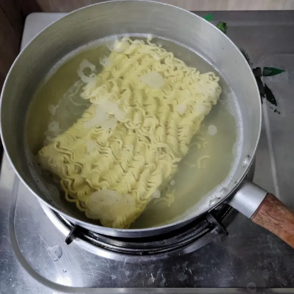 Didihkan air, masak mie telur 2 menit saja. Matikan api, lalu biarkan mengembang selama 15 menit.