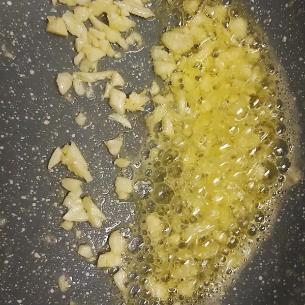 Disisi lain dengan api kecil panaskan teflon  masukkan butter tumis bawang putih hingga harum agak berwarna kuning tapi tidak perlu kering .