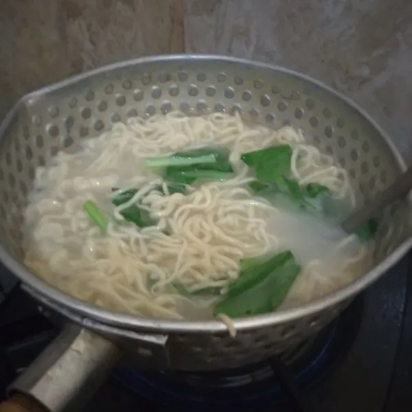 Tambahkan sawi masak hingga mendidih dan mie sedikit mengembang. matikan api. Tiriskan.
