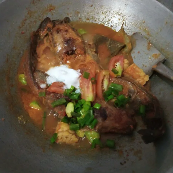 Setelah air menyusut, masukkan potongan tomat dan daun bawang, garam, kaldu ayam bubuk dan santan, aduk rata.