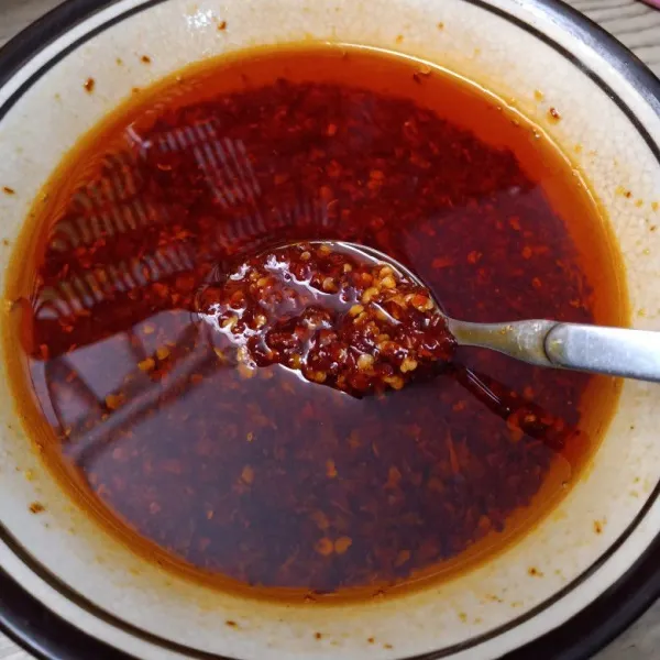 Masukkan minyak minyak panas ke dalam cabai kering di mangkuk, sambil diaduk perlahan nanti cabai akan termasak dan matang