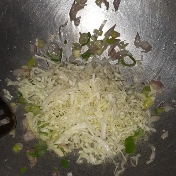 Tumis bawang merah, bawang putih dan daun bawang hingga tercium wangi. Kemudian masukkan kubis. Tumis hingga merata.