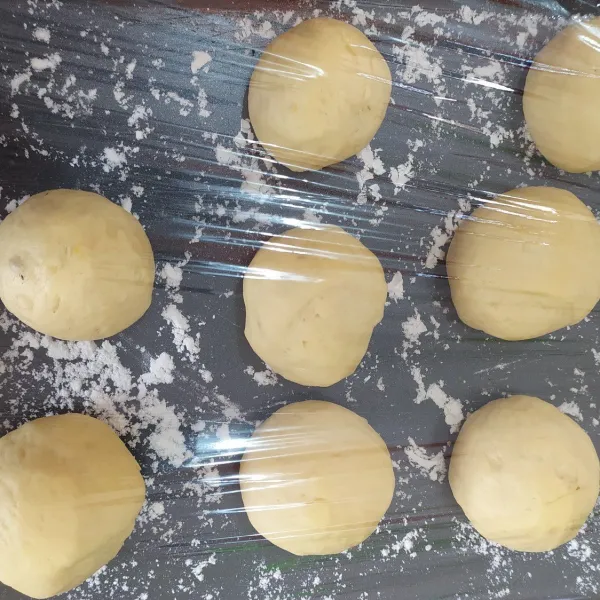 Bulatkan adonan. Dan susun beri jarak. Tutup lagi menggunakan plastik wrap dan biarkan mengembang.
