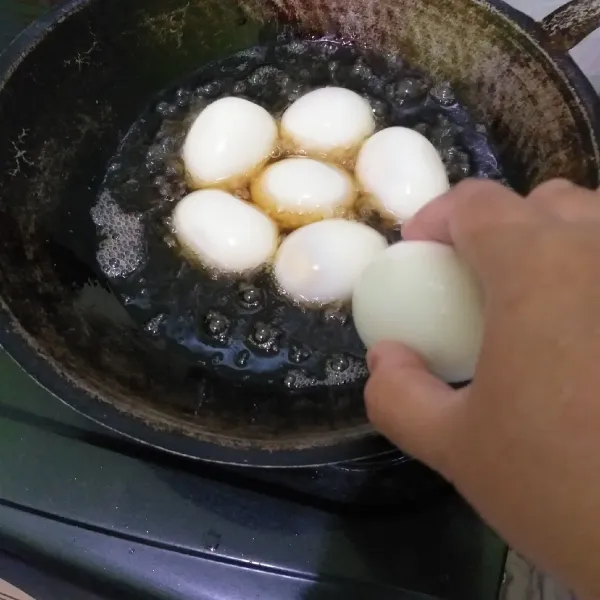 Rebus telur ayam, kupas dan goreng sampai berkulit.