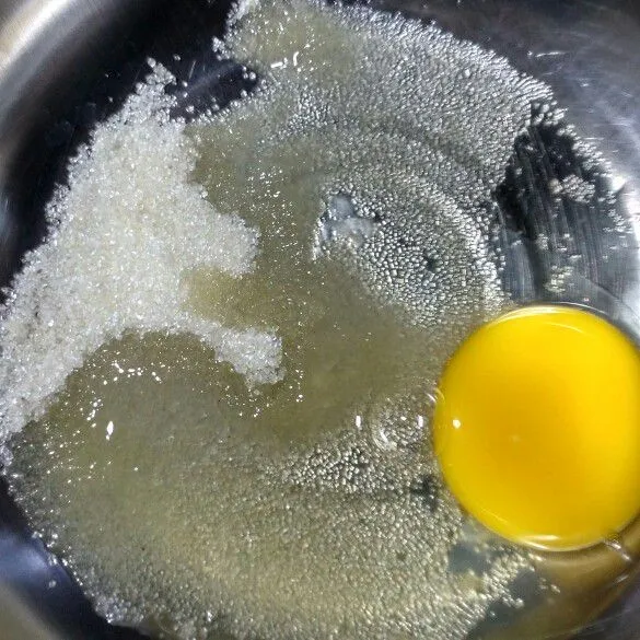 Di wadah terpisah, kocok telur dan gula hingga tercampur rata dan mengembang.