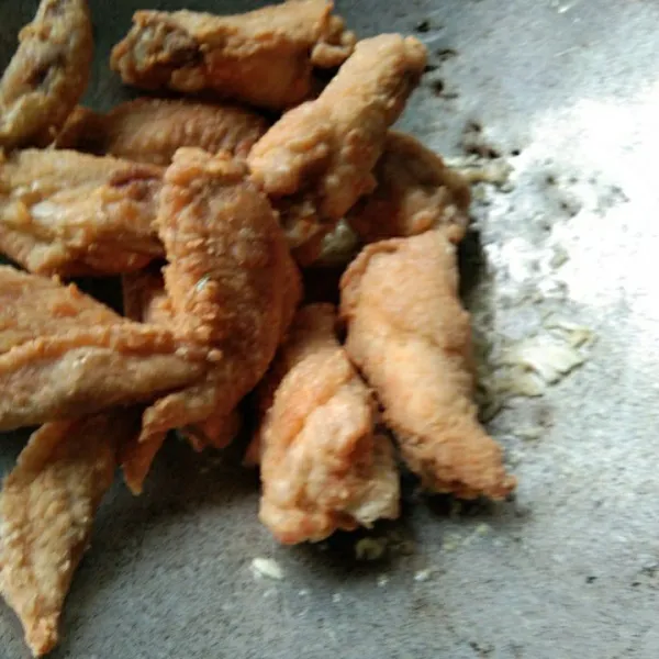 Tumis bawang putih hingga harum, masukan ayam goreng.