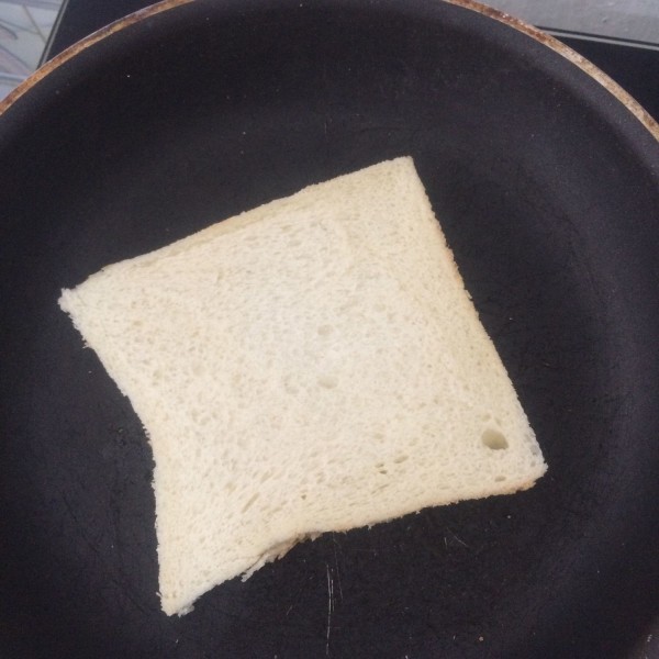 Panaskan wajan lalu panaskan satu sisi roti yang telah diolesi mentega, lakukan kepada kedua roti sampai berwarna keemasan