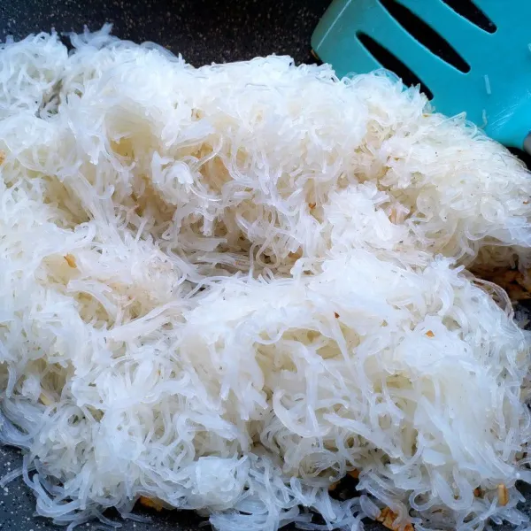 Masukkan bihun rebus, aduk-aduk.
