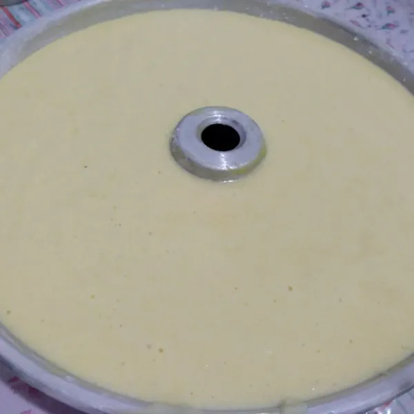 Tuang adonan di loyang tulban/bolu 28 cm yang telah dioles tipis mentega dan ditabur terigu. Hentakkan beberapa kali.