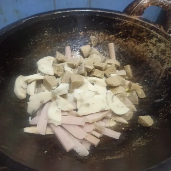 Setelah bawang bombay harum, masukkan sosis, baso, dan jamur. Tumis hingga matang.
