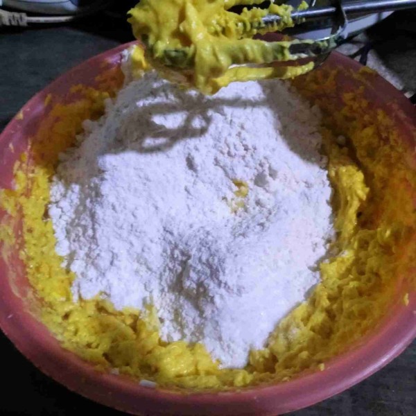Bergantian dengan sebagian tepung terigu sambil diayak dan dikocok rata. Masukkan sisa tepung, baking powder, dan maizena sambil diayak dan dikocok rata. Sisihkan.