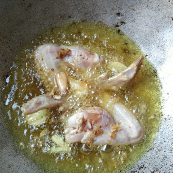 Goreng ayam beserta bawang putih hingga matang dengan api kecil.