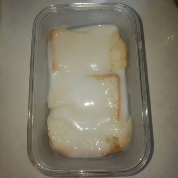 Siapkan wadah, tata satu lembar roti tawar di dasar wadah,lalu siram dengan vla susu.