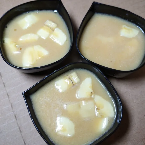 Tuang adonan yang sudah tercampur rata ke atas pisang.