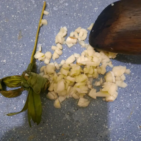 Tumis bawang putih dan daun kunyit hingga harum.