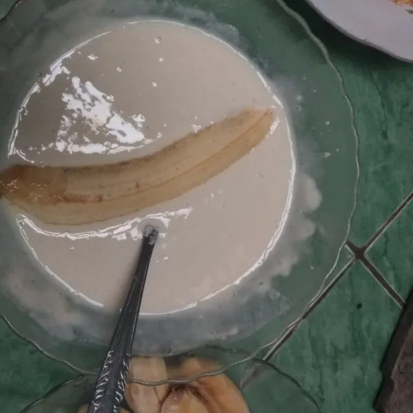 Masukkan satu persatu pisang ke dalam adonan tepung.