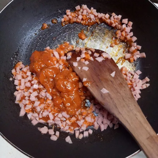 Panaskan margarin, lalu masukkan saos spaghetti dan sosis yang sudah di cincang. Tambahkan 3 sdm air. Lalu aduk rata dan sedikit mengental.