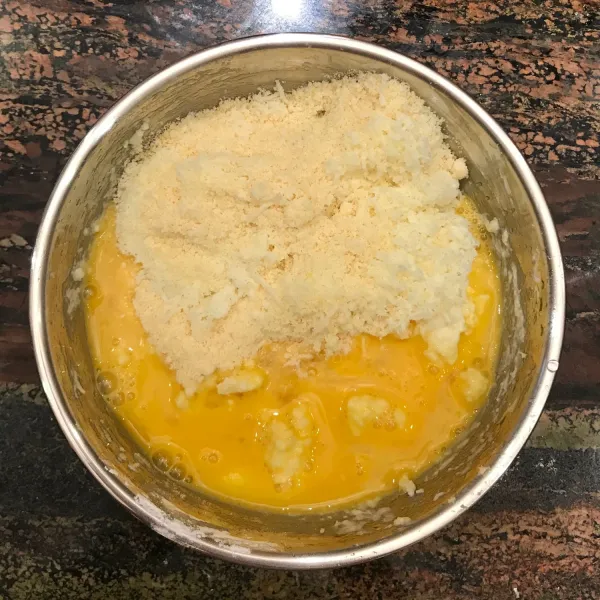 Masukan telur, keju mozarella, dan keju parmesan ke dalam adonan yang sudah tidak panas. Aduk hingga merata.