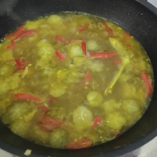 Masukkan belimbing sayur dan tomat. Tambahkan garam, lada, dan kaldu jamur bubuk.