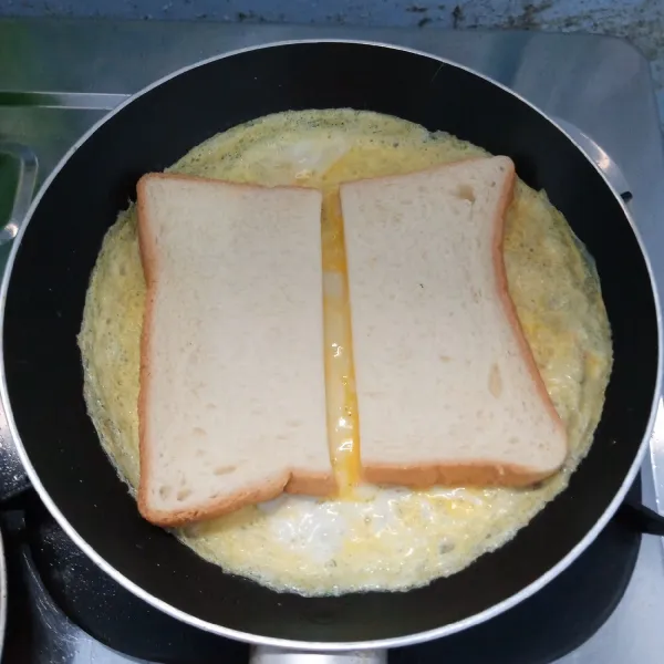 Kocok telur. Kemudian dadar. Taruh roti diatas telur dadar dengan diberi jarak.