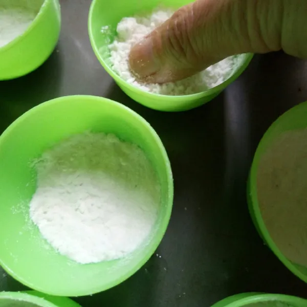 Masukkan tepung ke dalam cetakan talam yang sudah diolesi minyak. Isi dengan 1/3 bagian lalu padatkan.