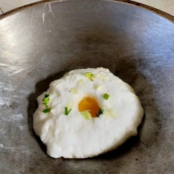 Tuang putih telur ke panci lalu masak putih telur dengan menutup panci menggunakan sedikit minyak. Saat setengah memadat, letakan kuning telur di atas putih telur dan taburkan daun bawang. Masak hingga putih telur memadat.