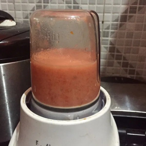 Potong tomat menjadi beberapa bagian untuk dihaluskan dengan blender, lalu sisihkan.