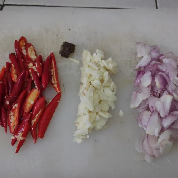 Iris tipis bawang merah, bawang putih, dan cabai rawit.