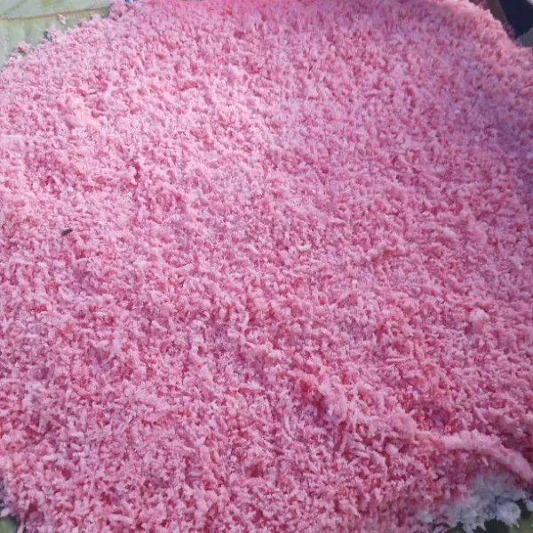 Masukkan beberapa tetes pewarna makanan ke kelapa parut lalu aduk sampai rata. Masukkan separuh adonan, aduk sampai berubah warna menjadi merah lalu ratakan di atas adonan yang putih.