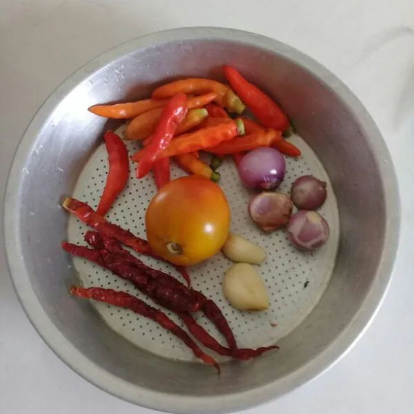 Cuci bersih bahan sambal lalu potong tomat menjadi 4 bagian.
